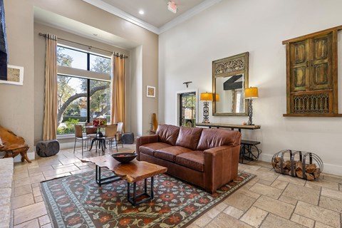 a living room with a leather couch and a rug